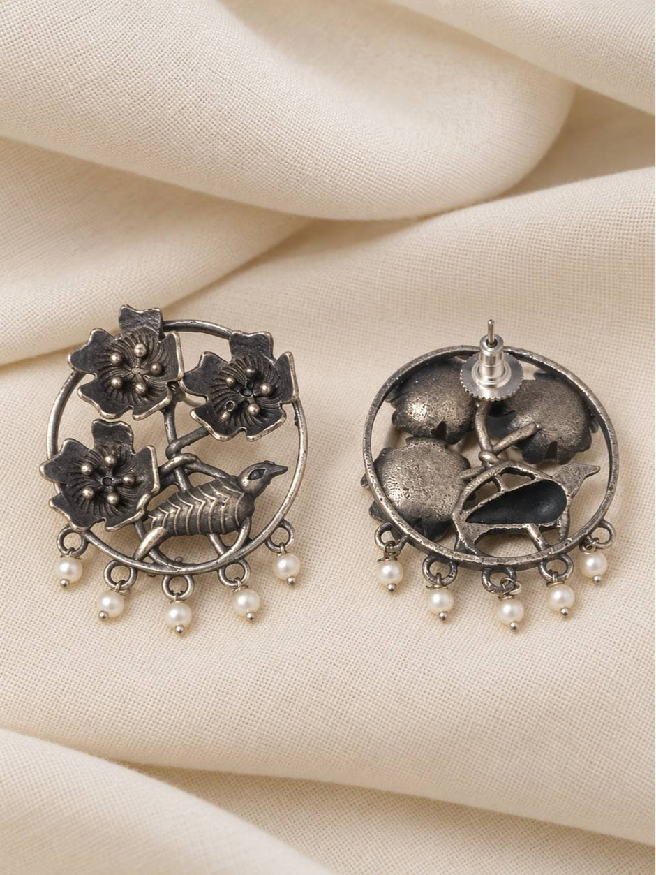 Front and back view of oxidised silver chandbali earrings showing push-back stud closure on cream fabric
