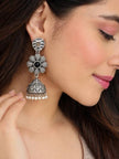 Woman wearing large oxidised silver floral jhumka earring with black stone and pearl drops