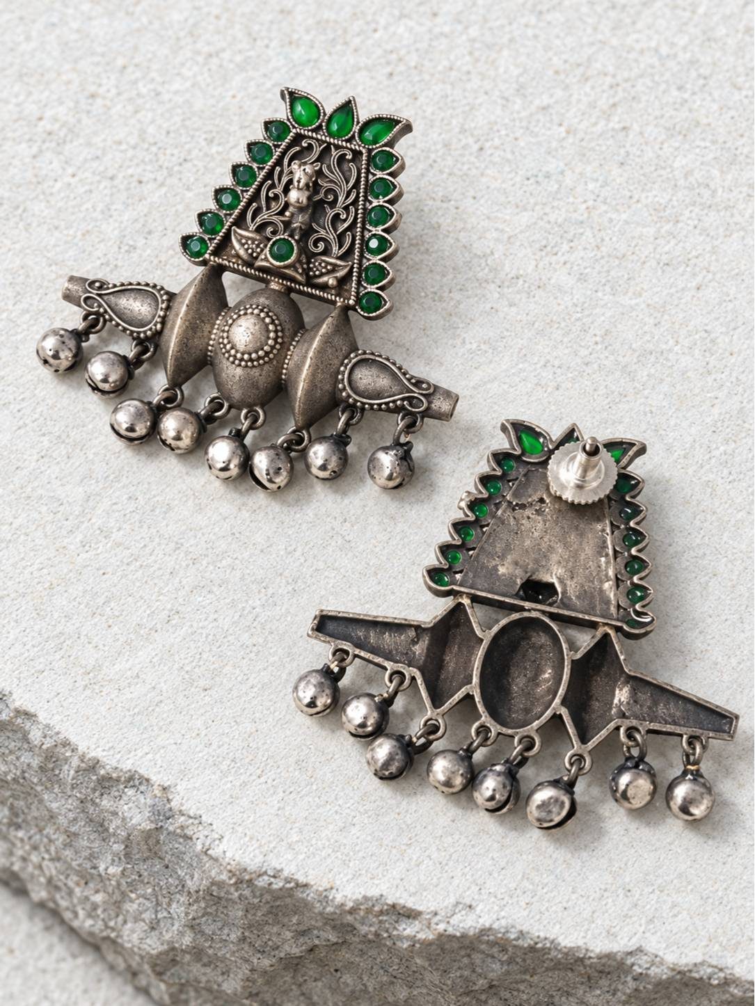 Front and back view of oxidised silver chandbali earrings showing deity motif and push-back stud fitting on grey stone