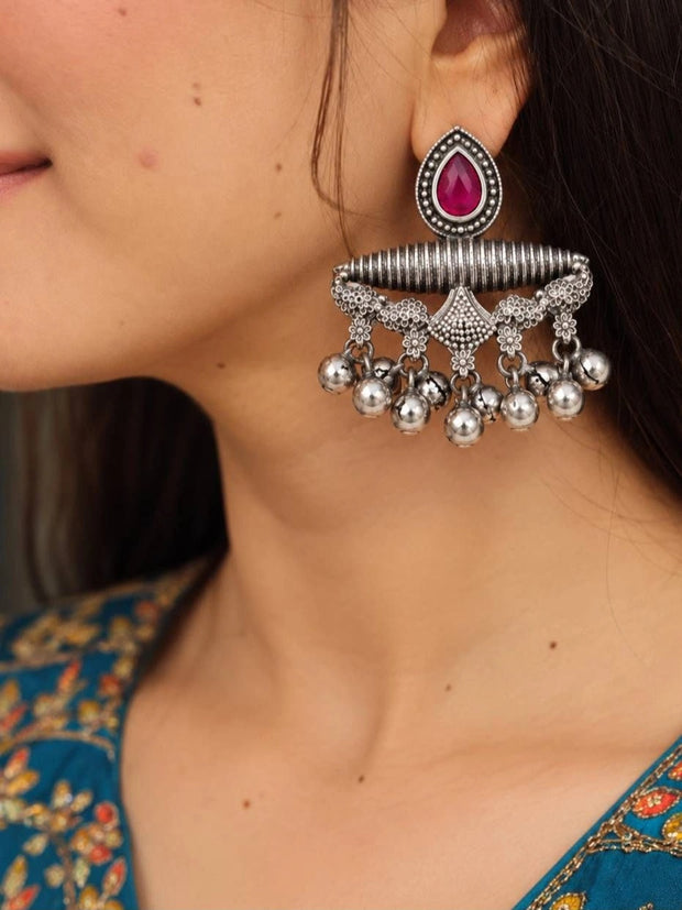 Woman wearing oxidised silver chandbali earring with pink teardrop stone and silver ghungroo ball drops, styled with a teal floral kurta