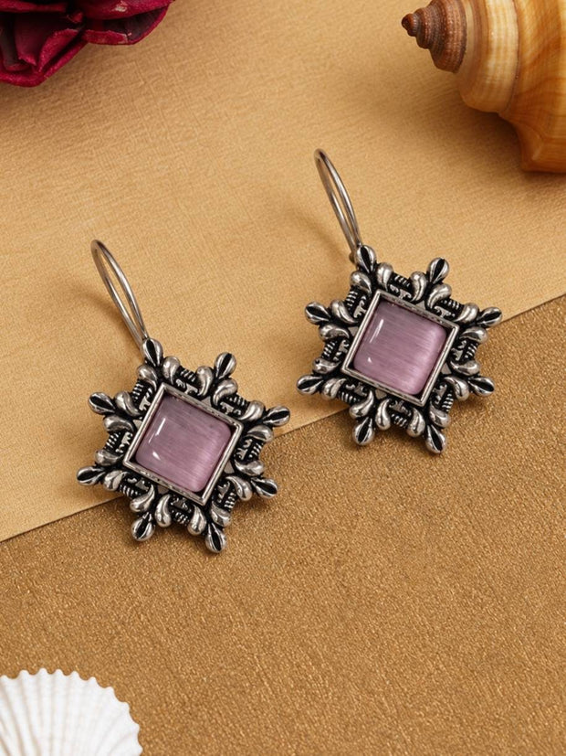 Front view of oxidised silver floral frame earrings with square lavender cat-eye stone