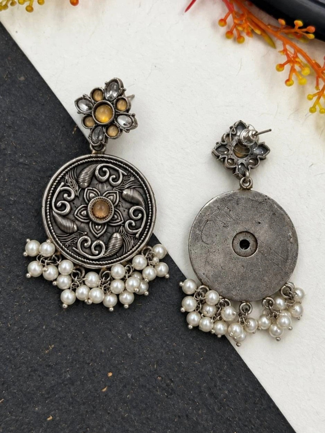 Front and back view of oxidised silver chandbali earring showing lotus engraving and plain reverse side
