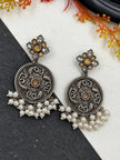 Close-up of oxidised silver chandbali earrings with amber stone flower stud top and white pearl drop fringe
