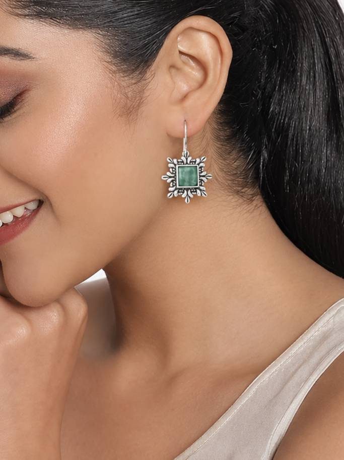 Woman wearing oxidised silver square green stone drop earring on shepherd hook wire at her ear