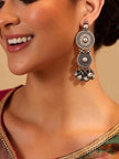 Woman wearing oxidised silver dual disc ghungroo drop earring with a silk saree