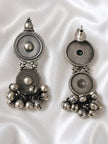 Front and back view of oxidised silver disc drop earrings with ghungroo bells on white satin