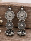 Pair of oxidised silver concentric disc earrings with bell clusters on wooden surface