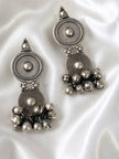 Side by side view of oxidised silver dual disc ghungroo earrings on white satin fabric