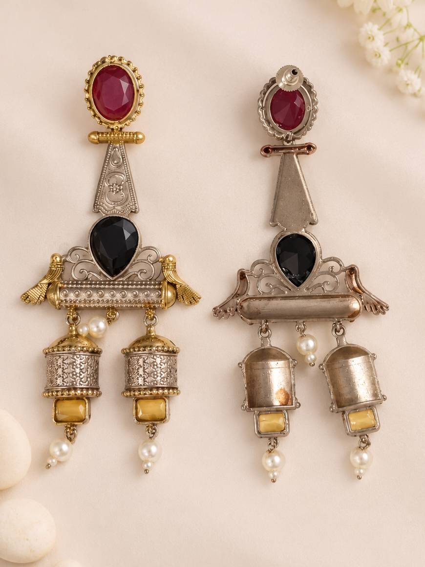 Front and back view of oxidised jhumka earrings side by side revealing engraved cylindrical danglers and plain reverse side