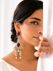Woman wearing one large oxidised dual-tone jhumka earring against a white draped background showing earring scale and drape