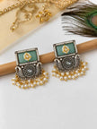 Pair of oxidised silver kundan rectangular drop earrings displayed on wooden rod with pearl fringe visible