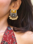 Oxidised silver chandbali earring with yellow resin stone and pearl drops worn on ear with red floral kurta