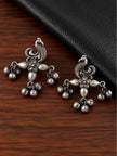 Pair of oxidised silver peacock drop earrings with ghungroo bells on wood