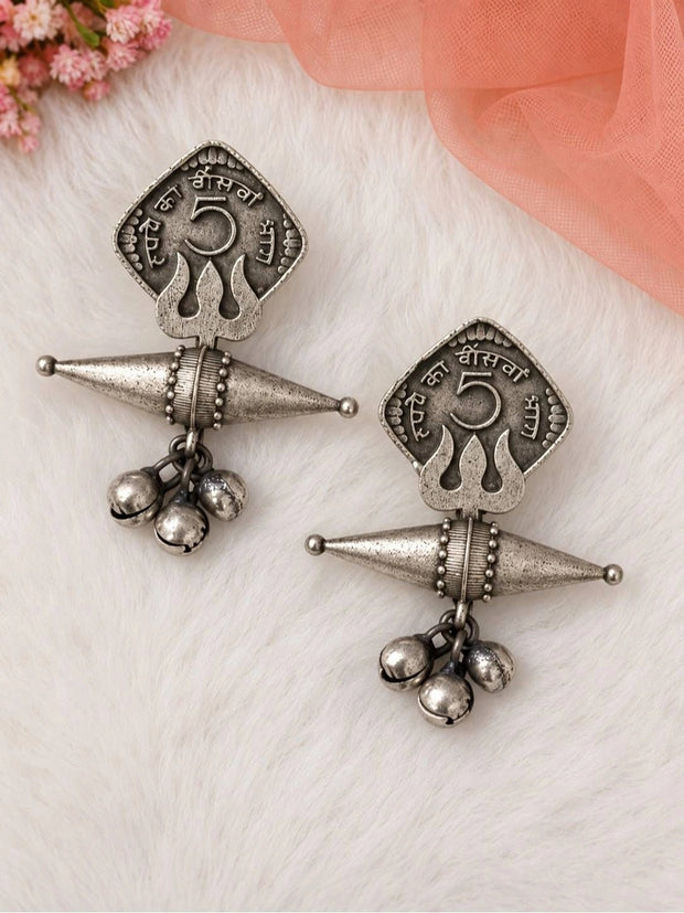 Front view of both oxidised silver coin earrings laid flat on a white fur surface with pink flowers