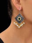 Oxidised silver diamond-shaped drop earring with green stone and white pearl clusters worn on a woman's ear