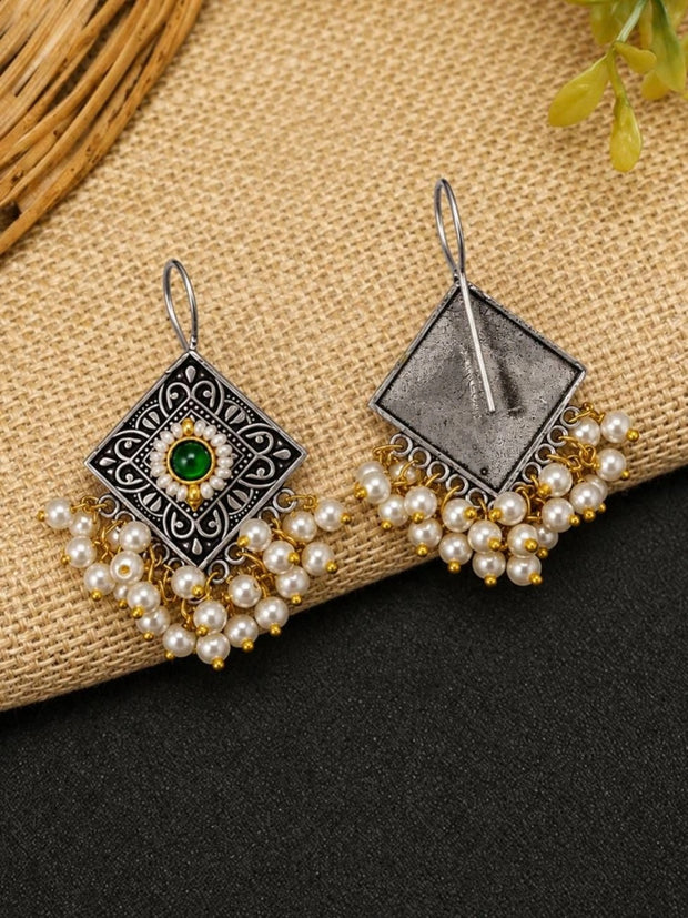 Front and back view of oxidised silver diamond earrings with pearl drops laid on natural jute fabric