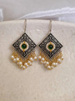 Both oxidised silver pearl drop earrings placed side by side on a white ceramic plate showing full design