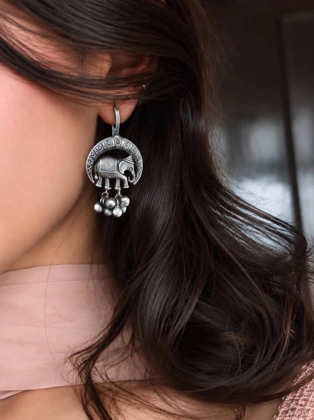 Oxidised silver elephant crescent earring with ghungroo drops worn on a woman's ear