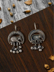 Front and back view of oxidised silver elephant earrings laid flat on a wooden surface