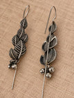 Front and back view of oxidised silver leaf earrings showing threader hook and ghungroo bells on linen