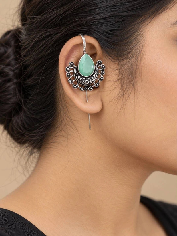 Oxidised silver crescent ear cuff with mint green teardrop stone worn on a woman's ear