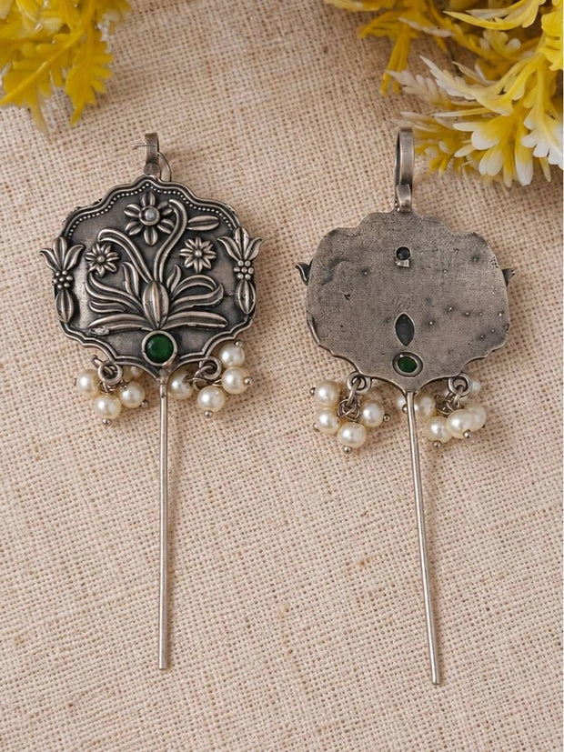 Front and back view of oxidised silver ear cuff earrings with green stone and pearl clusters on fabric