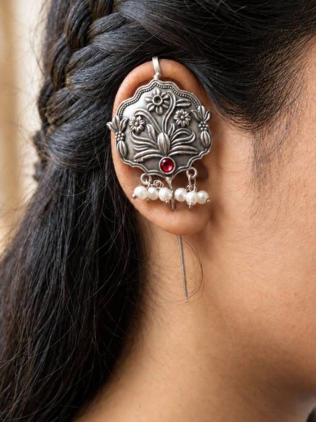 Oxidised silver floral ear cuff earring worn on a woman's ear showing lotus and daisy engraving with pearl drops