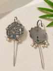 Front and back view of oxidised silver floral ear cuff earrings laid flat on white fabric