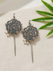 Pair of oxidised silver floral ear cuff earrings with turquoise stone and pearl drops on white fabric