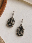 Front and back view of Ganesha drop earrings laid flat on white surface showing hook clasp