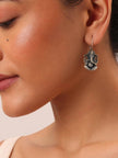 Close-up side profile of a woman wearing one Ganesha drop earring on her ear
