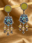Pair of oxidised silver geometric drop earrings with olive enamel studs, navy tribal pentagon and pink diamond dangles on golden fabric