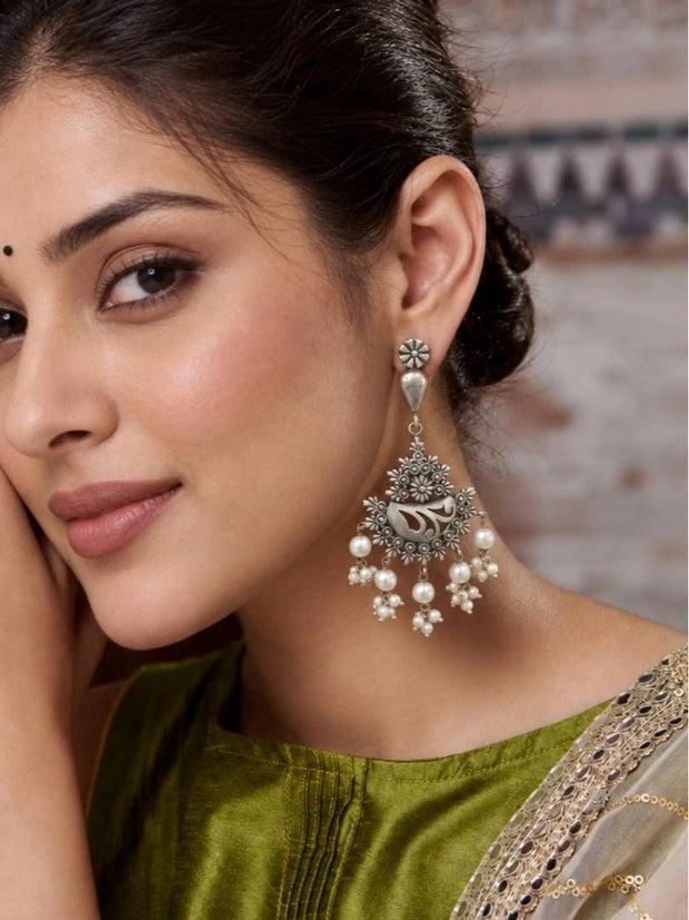 Model wearing oxidised silver floral chandbali earring with pearl drops paired with olive green silk kurta