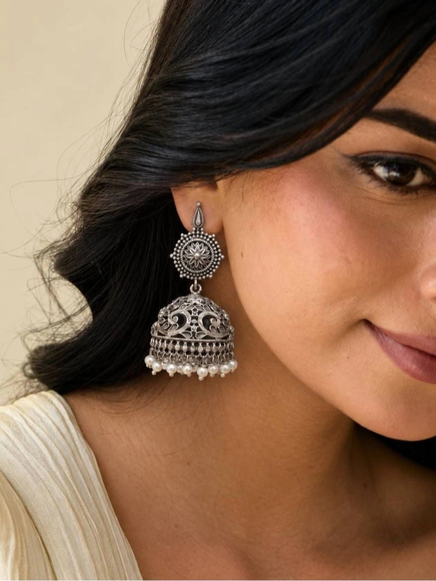 Woman wearing large oxidised silver jhumka earring with pearl drops and lotus stud top