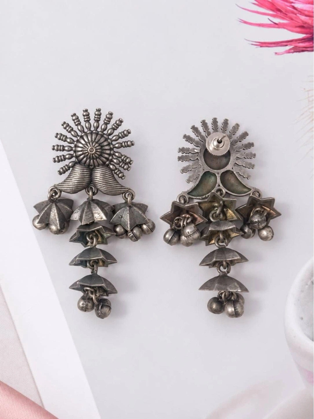 Front and back view of oxidised silver jhumka earrings showing screw-back closure and ribbed petal body