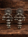 Pair of oxidised silver tiered jhumka earrings displayed on a dark wooden surface showing cascading umbrella tiers