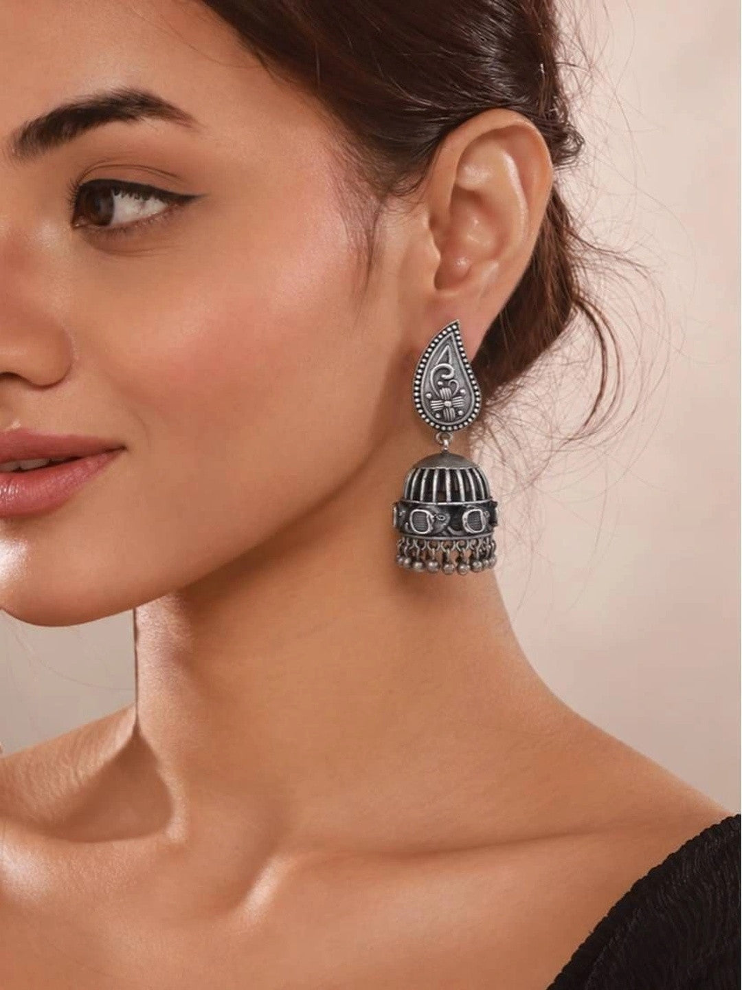 Woman wearing oxidised silver birdcage jhumka with paisley stud top and ghungroo bead fringe