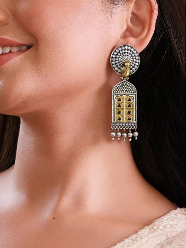 Model wearing oxidised silver dual-tone jhumka earring showing full length drop against neck and white outfit