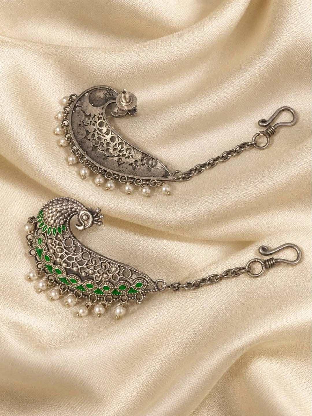 Front and back view of oxidised silver peacock ear cuffs showing filigree detail and chain fastening