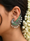 Peacock ear cuff worn on a woman's ear with jasmine flowers in hair showing full drape and pearl drop fringe