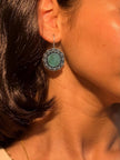 Oxidised silver floral circular earring worn on a woman's ear showing scale and fit