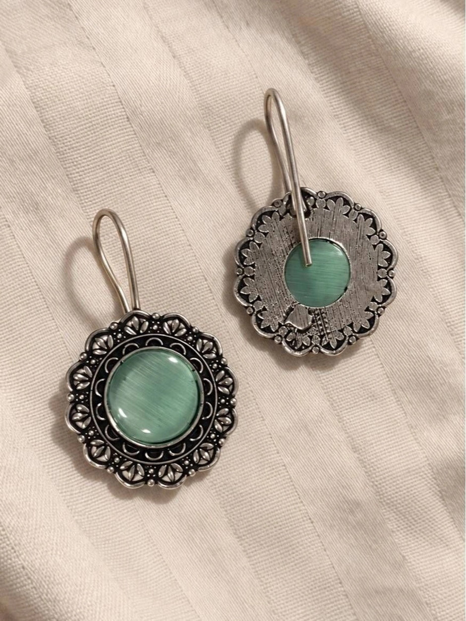 Front and reverse side of oxidised silver circular earrings showing textured metal back on white fabric