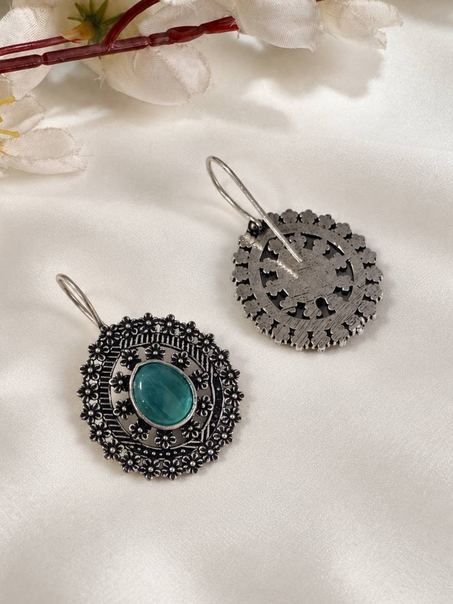 Front and back view of oxidised silver floral disc earrings showing reverse cutwork design