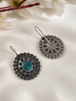 Front and back view of oxidised silver floral disc earrings showing reverse cutwork design