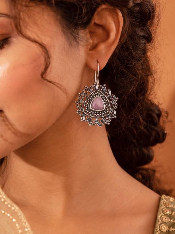 Woman wearing oxidised silver filigree drop earring with pink stone styled with embroidered ethnic top