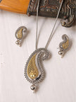 Flat lay of oxidised dual-tone paisley pendant necklace and stud earrings on white surface near antique wooden box