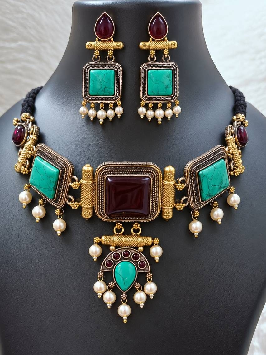 Antique gold turquoise choker necklace and matching dangler earrings displayed on a dark jewellery bust