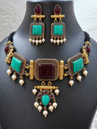 Antique gold turquoise choker necklace and matching dangler earrings displayed on a dark jewellery bust