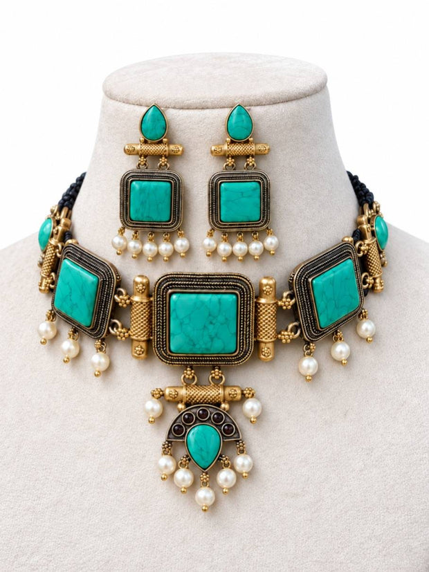 Turquoise stone oxidised gold choker necklace and square earring set displayed on a cream jewellery bust