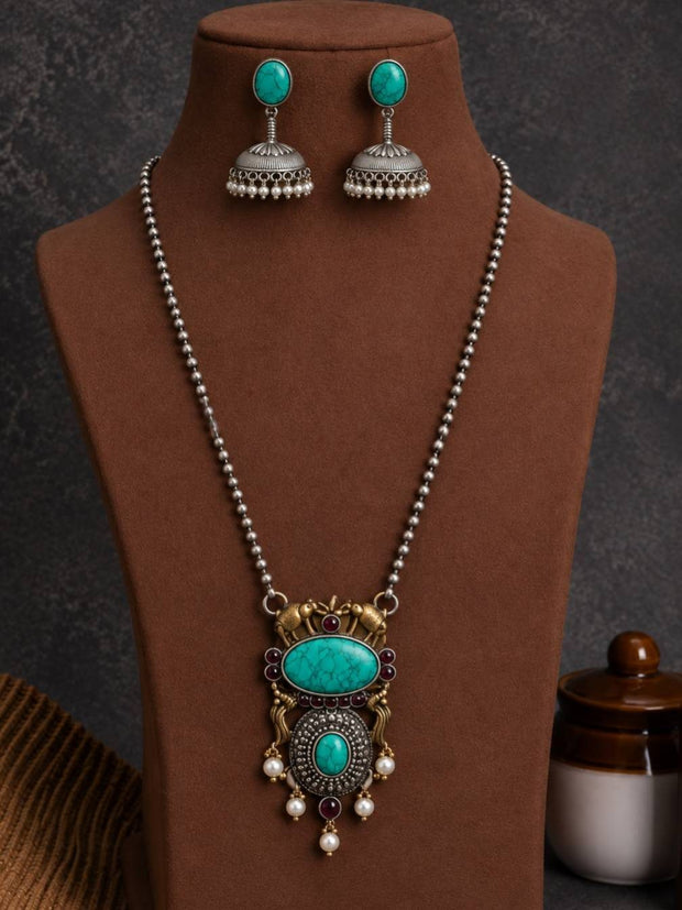 Oxidised silver turquoise pendant necklace and jhumka earring set displayed on a brown jewellery bust